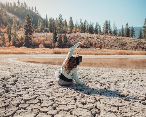Woman practicing yoga outdoors in nature at sunset
